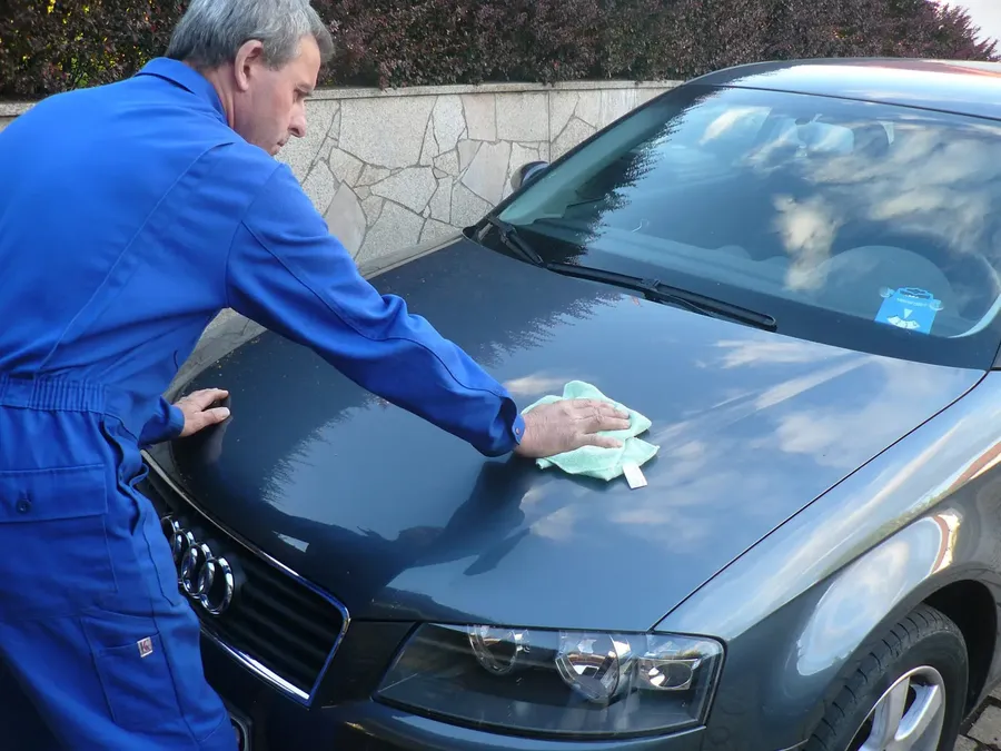 Lothar Zeitler poliert die Motorhaube eines Autos